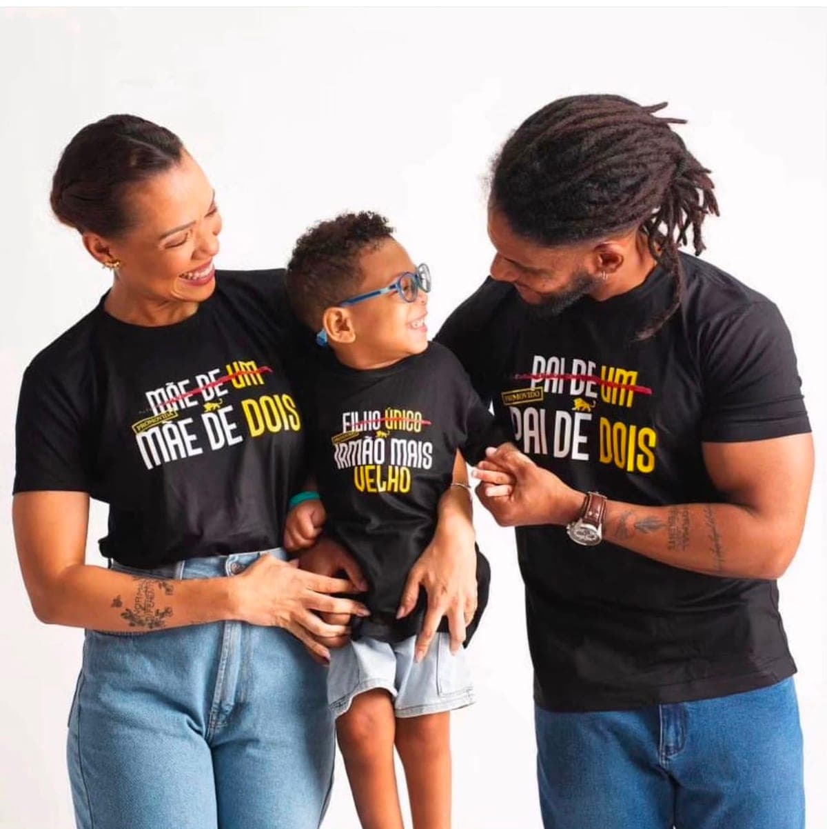 Família vestindo camisetas personalizadas da Lion Brazil com as estampas Mãe de dois, Irmão mais velho e Pai de dois