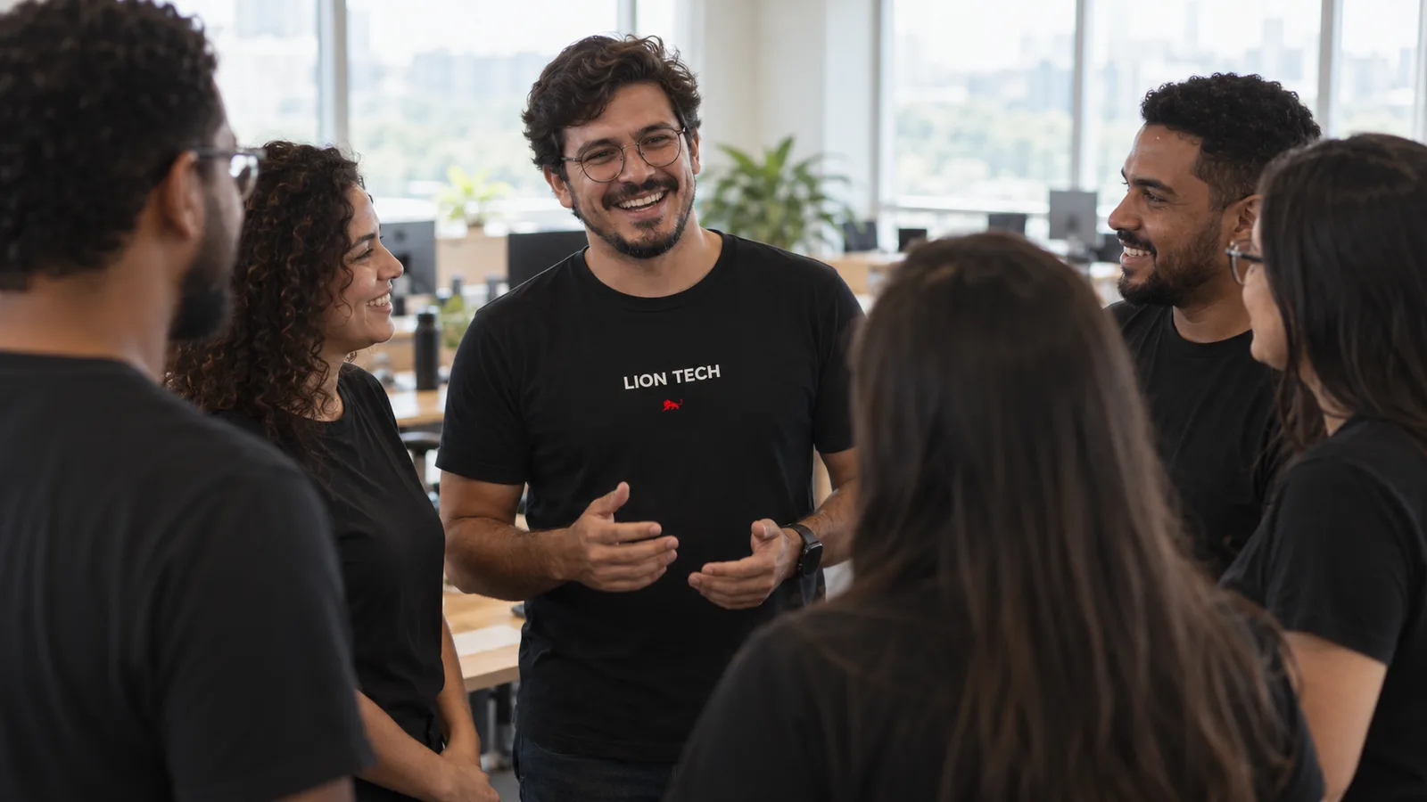 Time de tecnologia em roda perto do quadro branco, todos com a mesma camiseta preta em modelagens diferentes