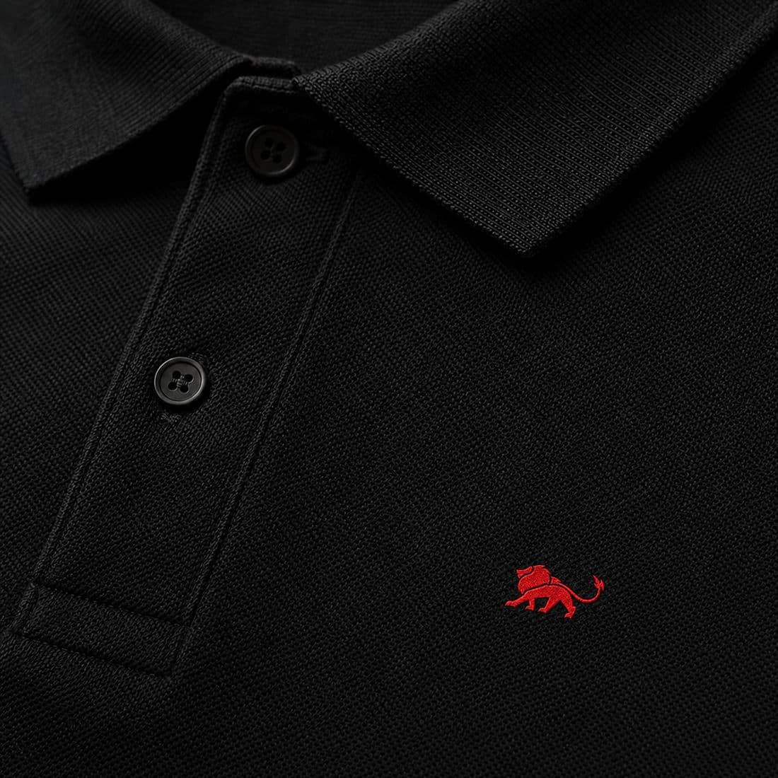 Bordado do leão Lion Brazil no peito de camisa polo preta de uniforme