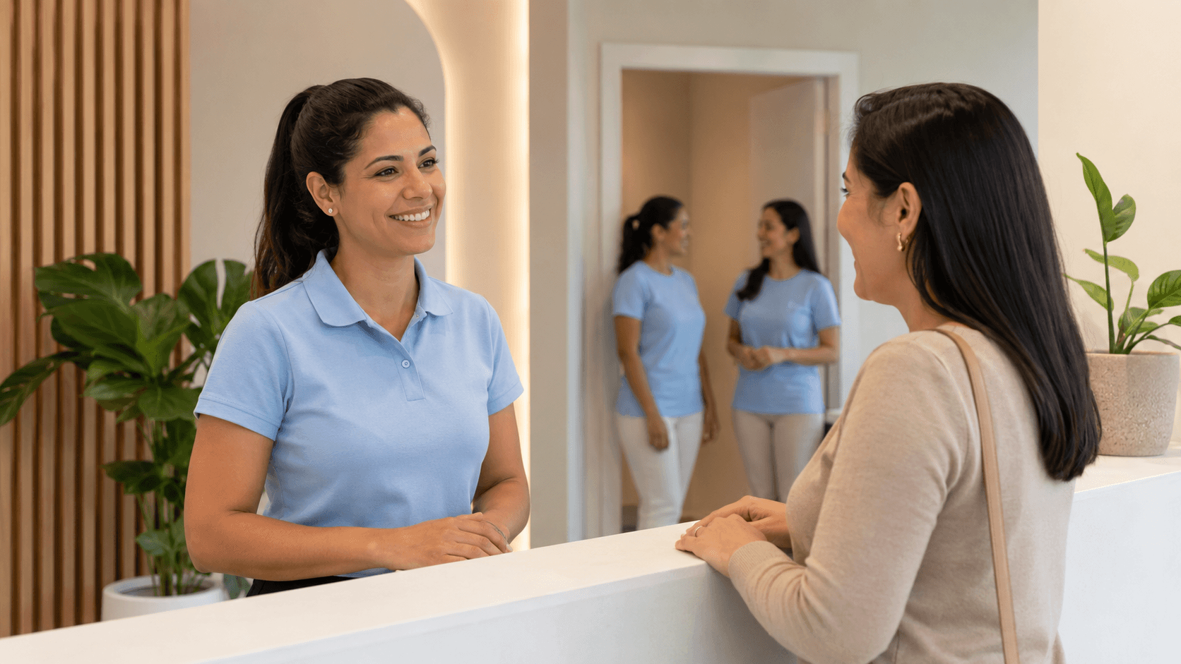 Recepcionista de polo azul-clara recebendo paciente no balcão da clínica odontológica