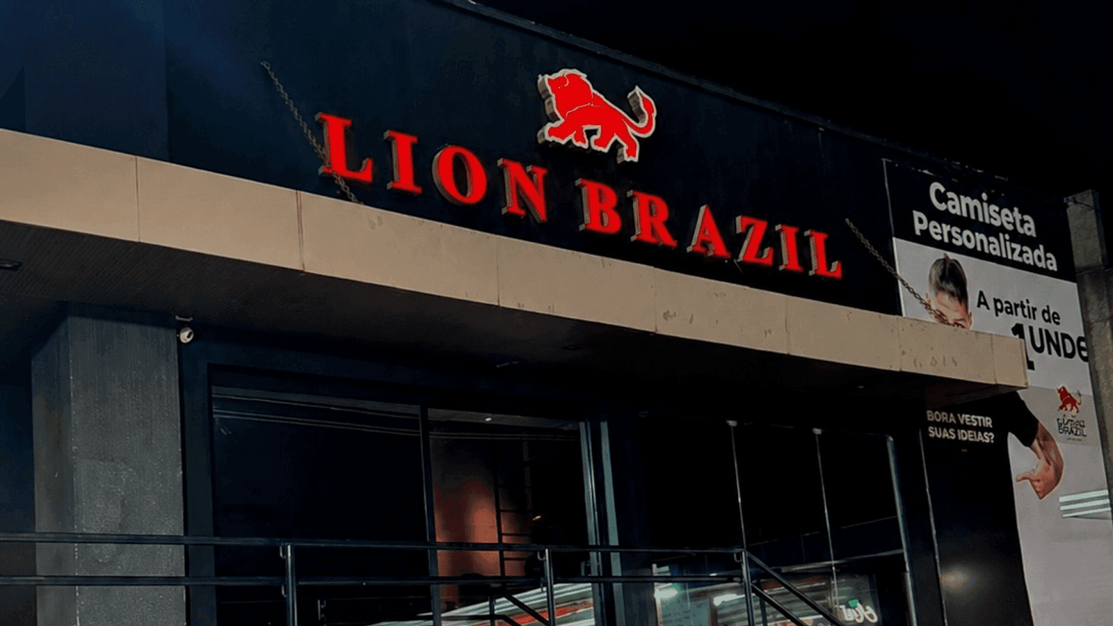 Fachada da loja da Lion Brazil em Natal a noite, com o letreiro vermelho iluminado, no ultimo mes neste endereco