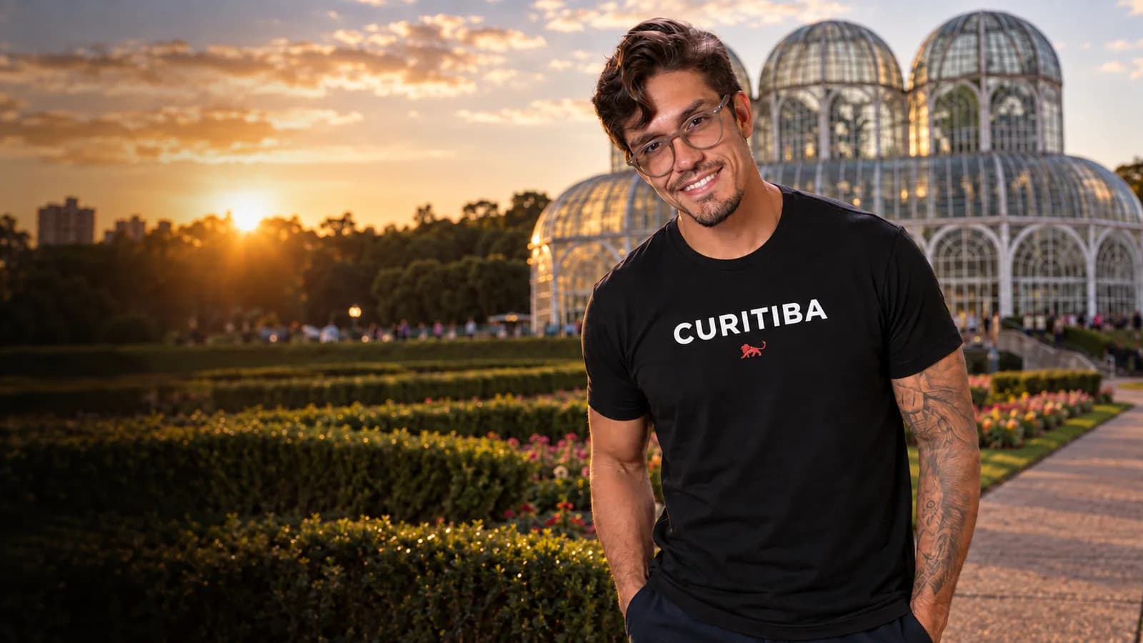Pedro Costa, fundador da Lion Brazil, com camiseta preta estampada "Curitiba" e o leão da marca, em frente a a estufa do Jardim Botânico
