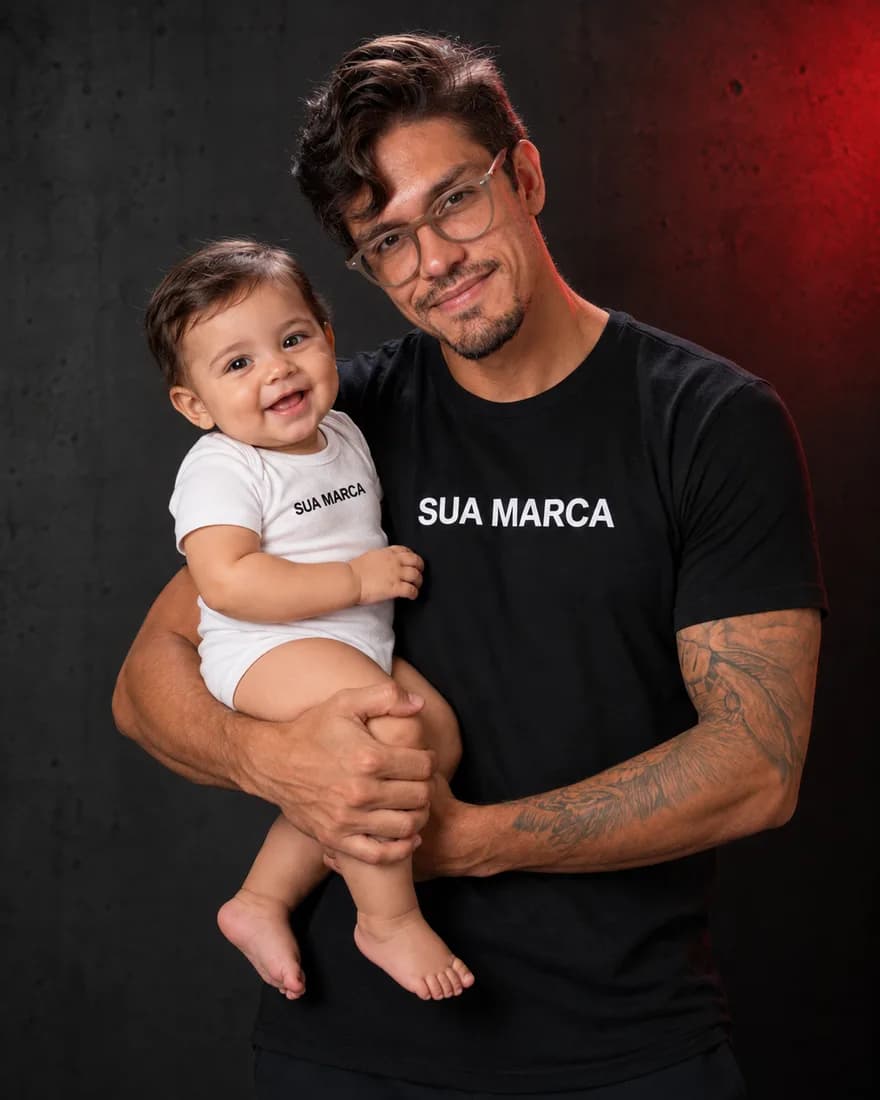 Pedro Costa com um bebê no colo vestindo body branco com SUA MARCA