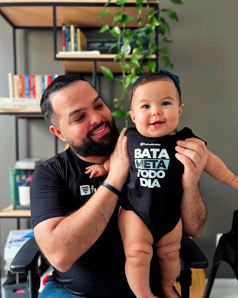 Pai segurando bebê que veste body personalizado da Lion Brazil