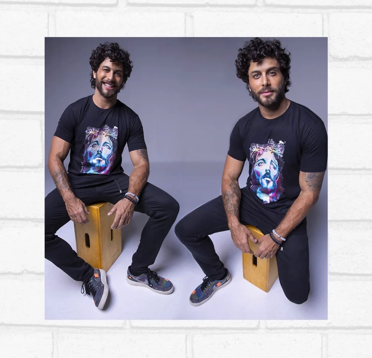 Jesus Luz sentado em estúdio com camiseta preta estampada com a arte de um rosto em pintura colorida, criada pela Lion Brazil