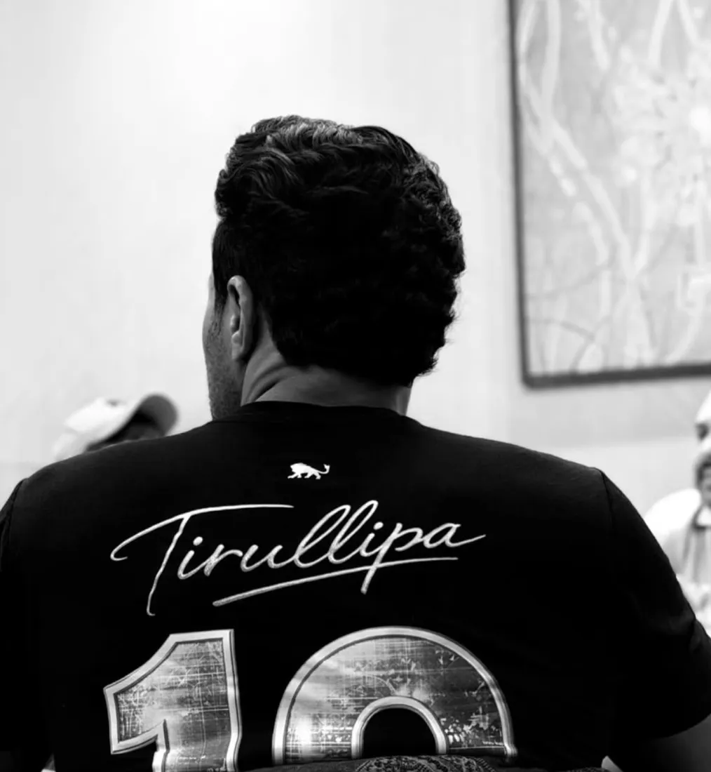 Tirullipa de costas vestindo camiseta preta da Lion Brazil com a assinatura Tirullipa, o número 10 e o leão da marca abaixo da gola