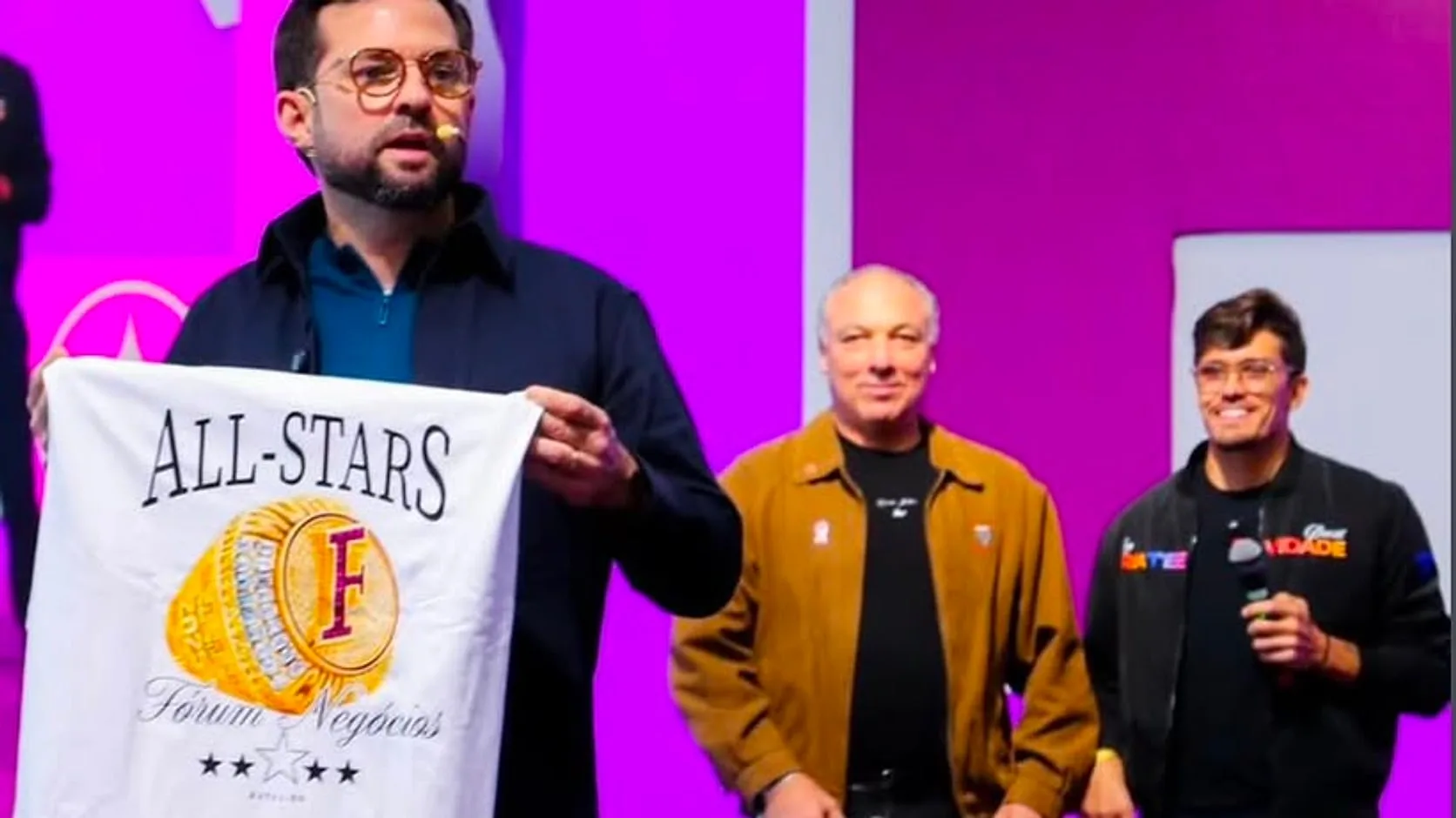 Camiseta personalizada em destaque durante apresentação em palco de evento.