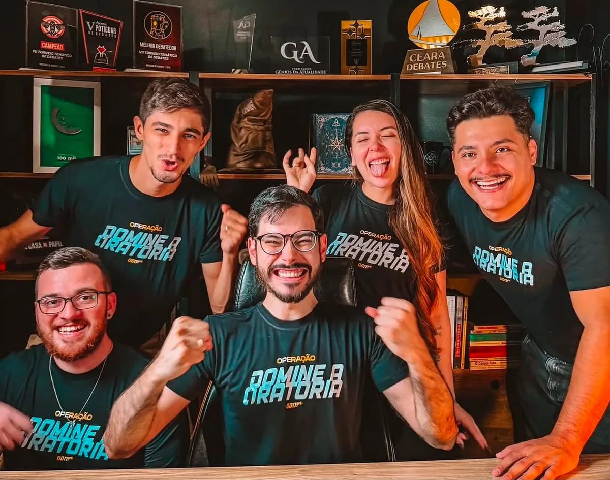 Equipe de cinco pessoas uniformizada com camiseta preta personalizada produzida pela Lion Brazil