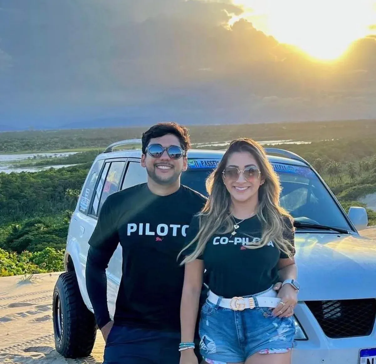 Casal em passeio de buggy nas dunas com camisetas Lion Brazil estampadas PILOTO e CO-PILOTA