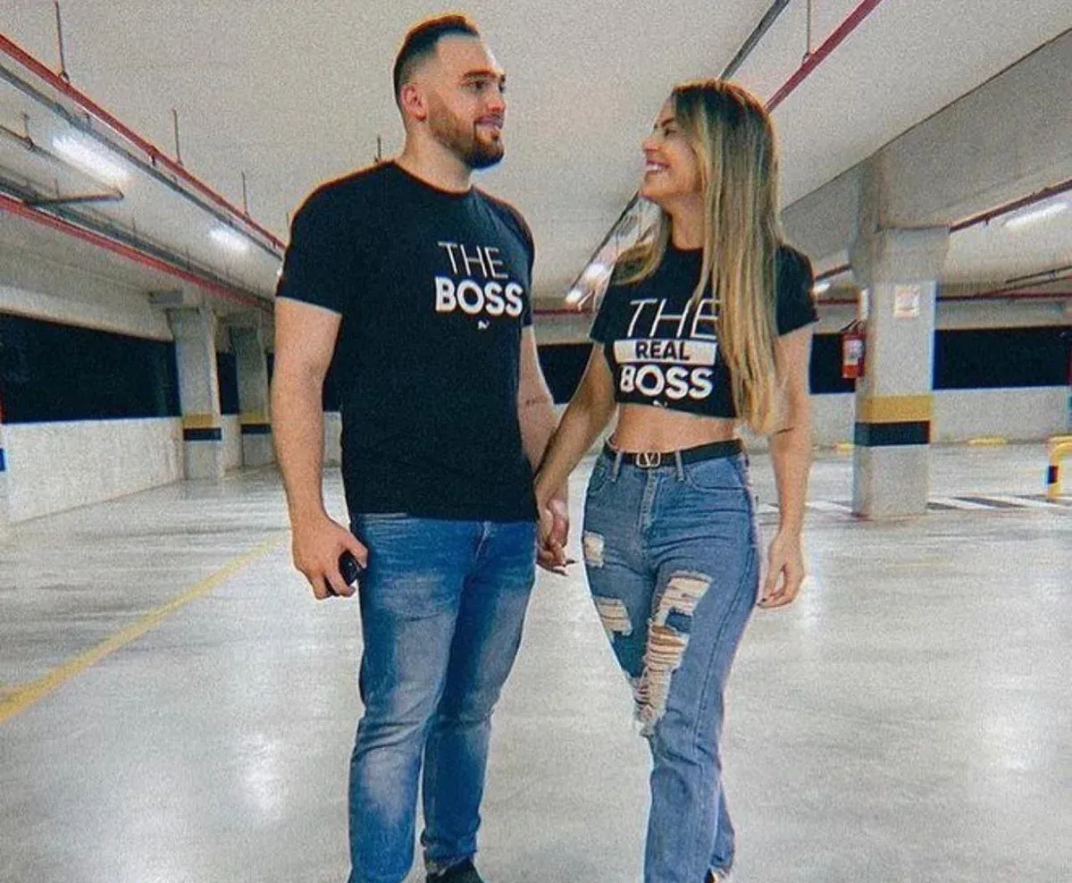 Casal de mãos dadas com camisetas pretas Lion Brazil estampadas THE BOSS e THE REAL BOSS